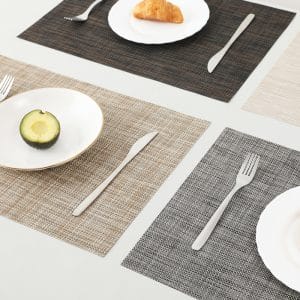 PVC table mats with embroidered hotel logos in a conference dining hall.