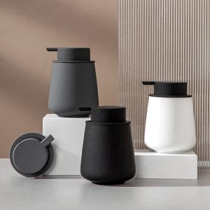 GRS-certified ceramic soap dispenser in hotel lobby, eco-conscious design with rubber paint coating