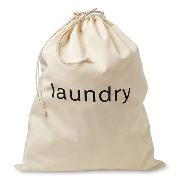 Canvas laundry bag with detachable detergent pocket, used in a Qatar luxury villa’s bathroom for toiletry storage.