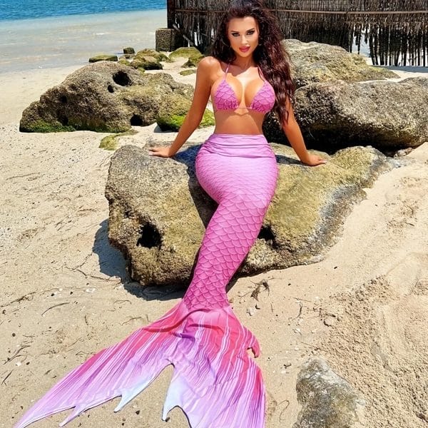 Guest reclining by pool with metallic gold swimmable mermaid tail, resort interior design