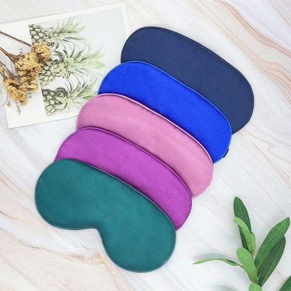 White satin eye mask with gold embroidery, adjustable Velcro strap, hotel room amenities, luxury sleep solution
