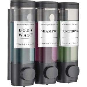 White ceramic wall-mounted shower soap dispenser with triple compartments for shampoo, conditioner, and body wash in a luxury hotel bathroom