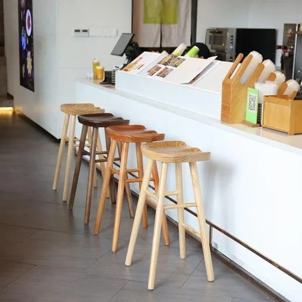 Hand-carved oak bar stools in Dubai luxury hotel bar with coastal backdrop