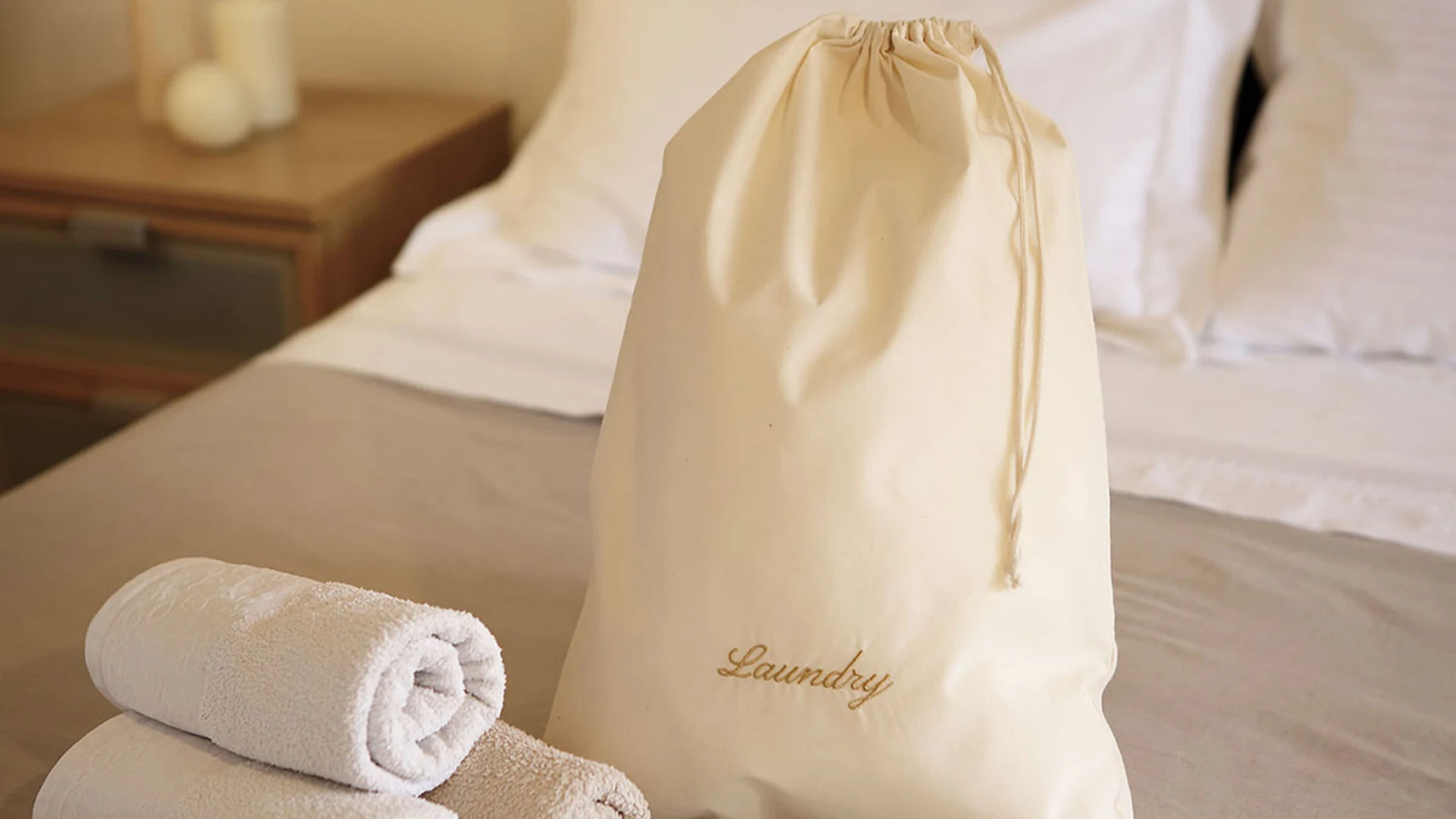 Large stack of various types of hotel laundry bags, showing bulk supply and consistent quality from DERBAL.