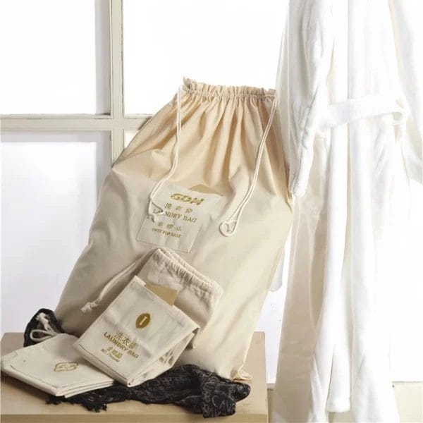 Stack of reusable organic cotton hotel laundry bags, emphasizing eco-friendly and sustainable materials.