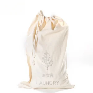 White non-woven hotel laundry bag with a convenient drawstring, placed neatly in a hotel guest room.