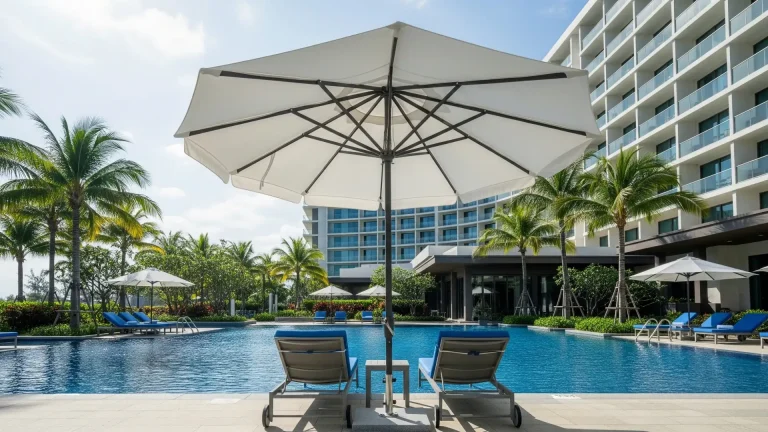 Guests relaxing on a shallow pool sun shelf under a specialized in pool umbrella, providing shade directly in the water.