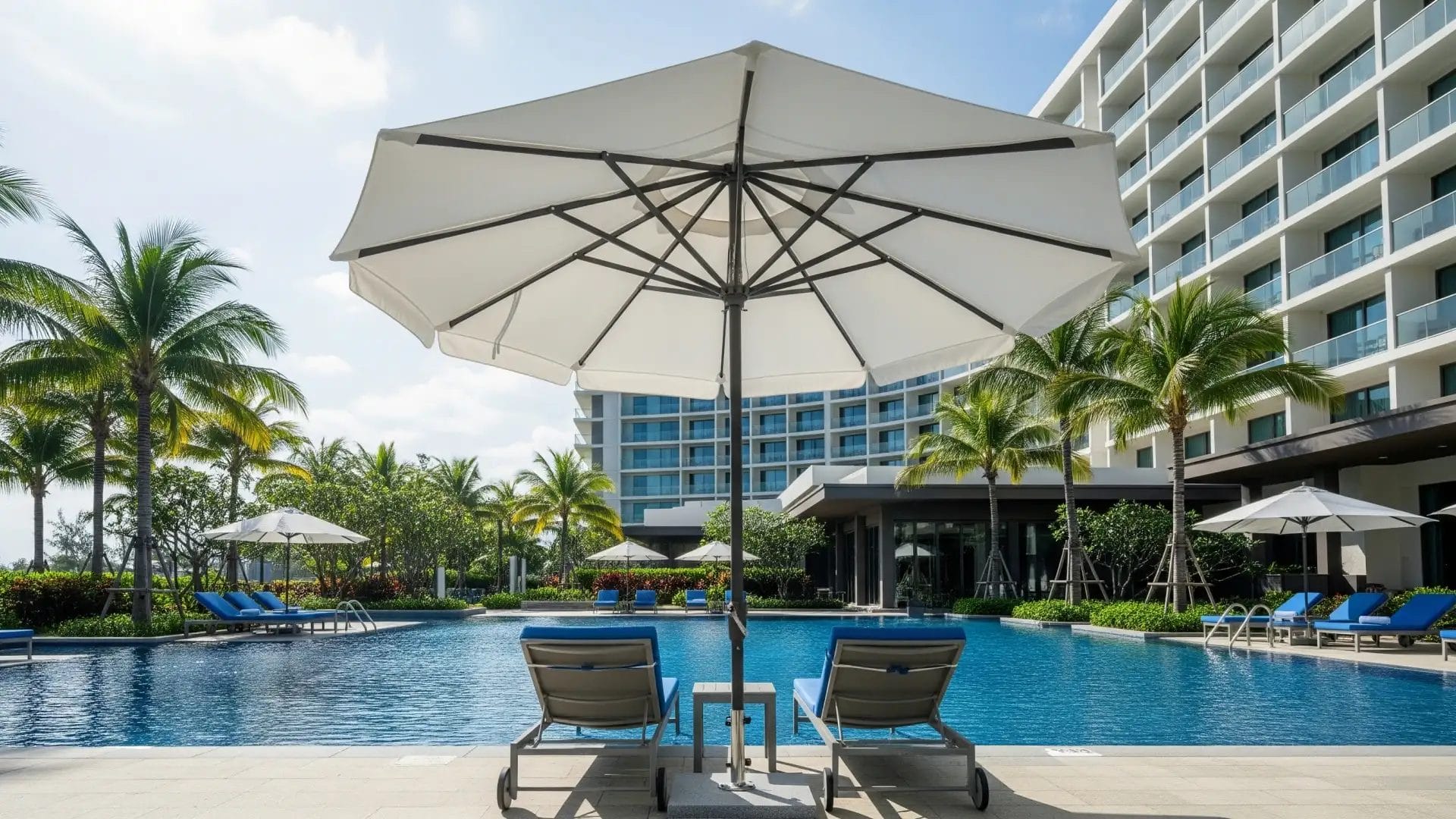 Guests relaxing on a shallow pool sun shelf under a specialized in pool umbrella, providing shade directly in the water.