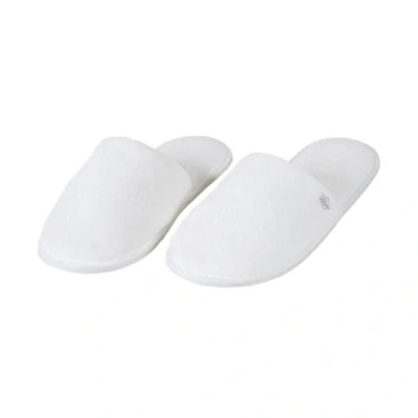A large stack of new Hotel Velour Slippers in bulk packaging, ready for distribution to hotel rooms.