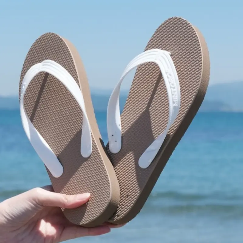 The durable construction of the Outdoor Beach Flip Flops Cheap Slippers on a sandy beach, showcasing its long-lasting material.