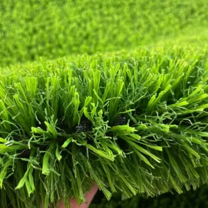A close-up of a sustainable, eco-friendly infill (like cork or walnut shells) in a Football Turf system.