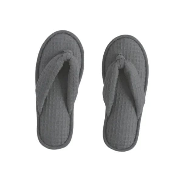 A stack of individually wrapped Waffle Slippers in bulk, demonstrating readiness for large-scale hotel and resort supply.