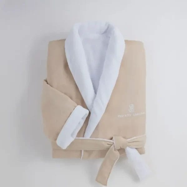 A neat, folded stack of beige and grey Luxury Hotel Bathrobes, emphasizing their quality, consistency, and readiness for hospitality use.