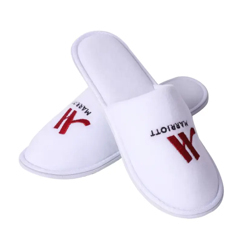 A Terry velvet Hotel Slippers presented with a small, green leaf or sustainable packaging, symbolizing its eco-conscious qualities.