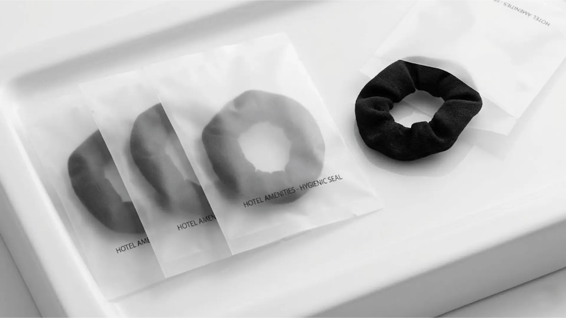 Close-up of individually wrapped wholesale hair ties in hygienic sachets for hotel guests.