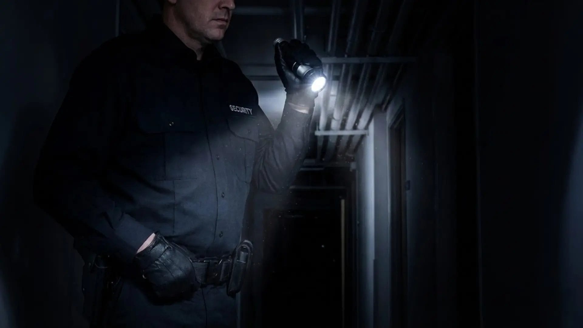 A security guard in a dark uniform uses a powerful Hotel Emergency torch to inspect a dark service corridor, demonstrating its utility for security patrols.