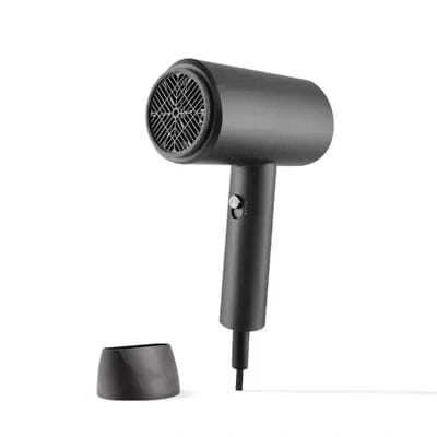 Guest using the hair dryer comfortably near a mirror, demonstrating low-noise operation and safety.