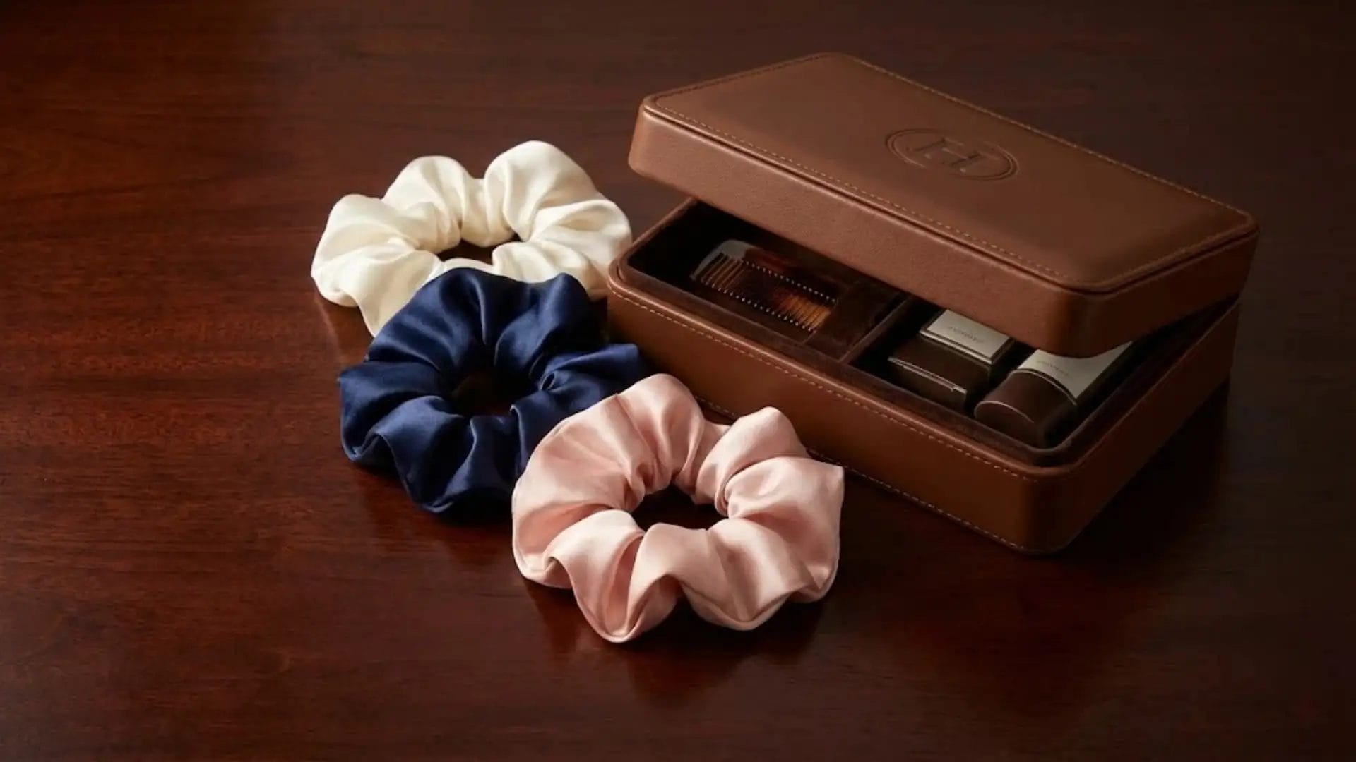 Assorted luxury silk scrunchies and a custom branded hotel vanity kit, showing wholesale customization options.