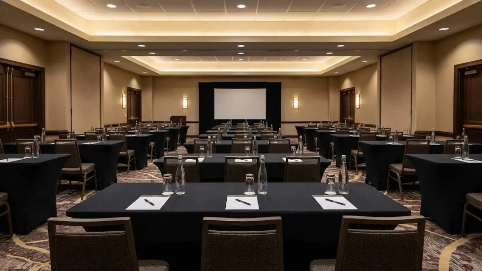 8ft rectangular banquet tables set up in a classroom style for a corporate conference in a US hotel.