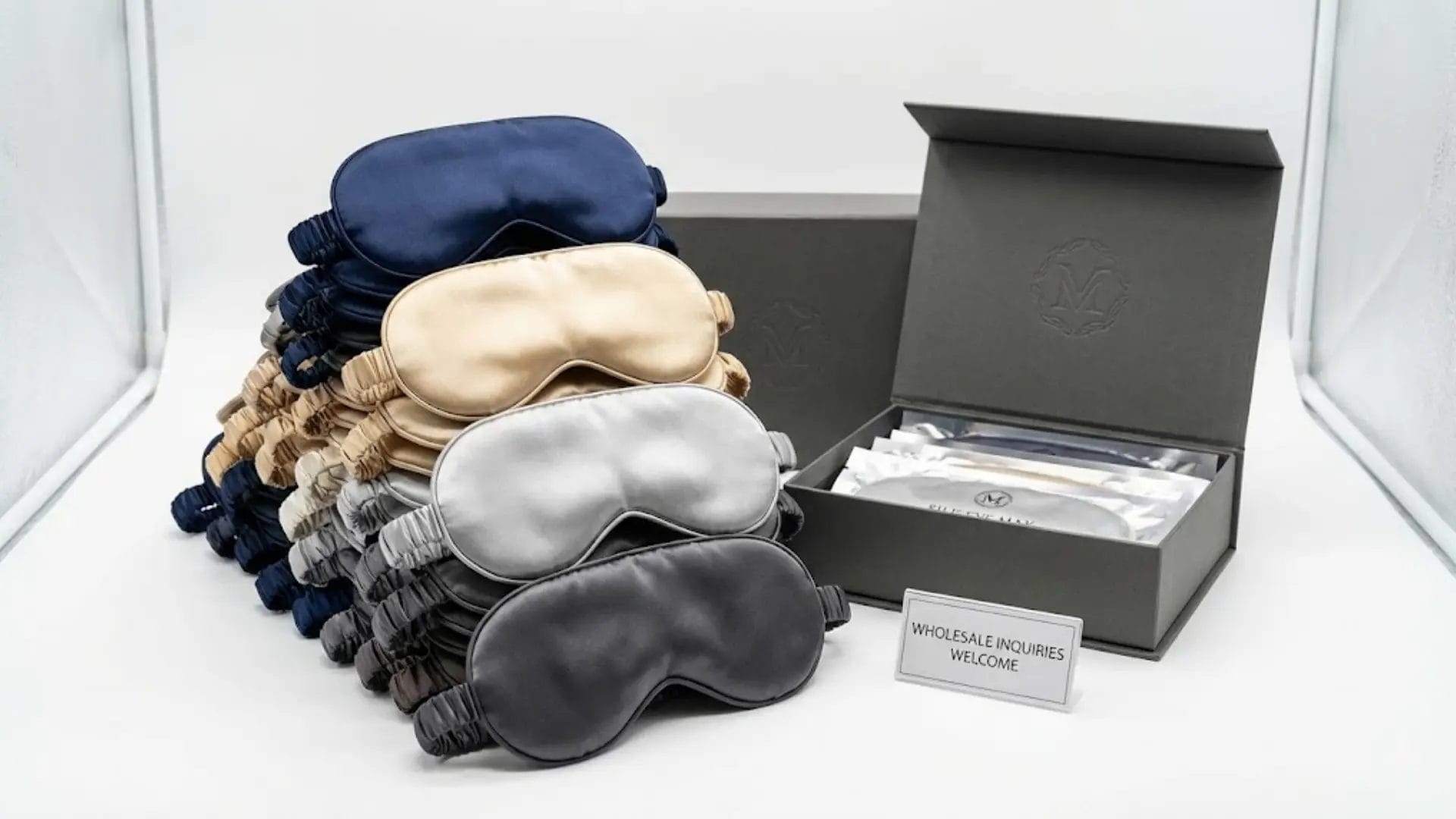 Stack of premium silk eye masks available for bulk wholesale and custom branding