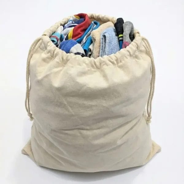 A filled 50.8x43cm cotton laundry bag demonstrating large capacity for guest clothes and resort wear.