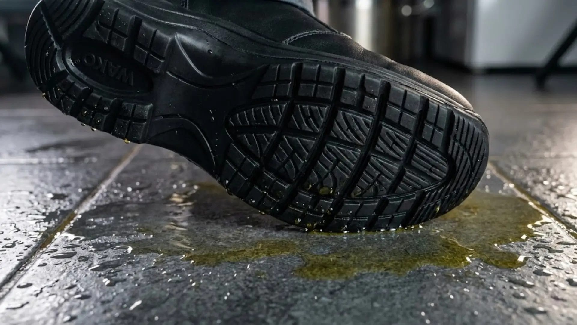 Macro shot of slip resistant shoes for work gripping a wet and oily resort kitchen floor.
