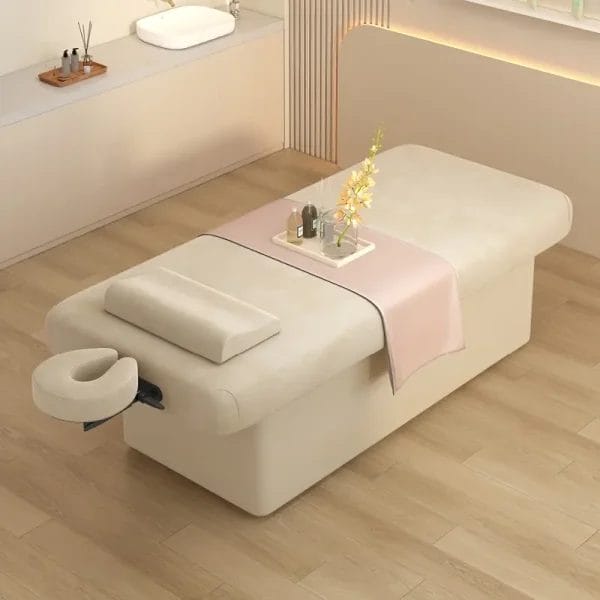 Beige spa massage bed with a detachable face cradle headrest and velvet fabric
