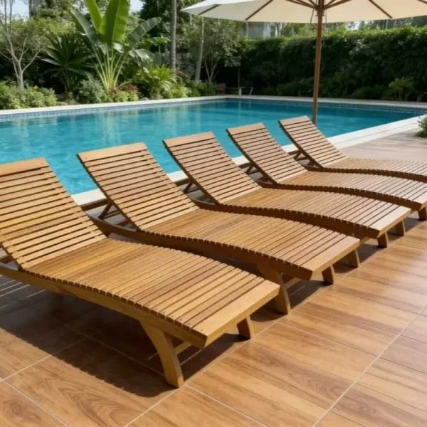 A luxurious commercial Teak Sun Bed with white cushions positioned beside a five-star resort infinity pool.