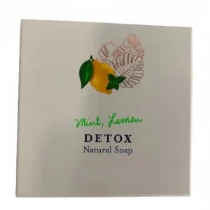 A beautifully packaged Mint and Hotel Soaps Lemon DETOX Natural Soap displayed elegantly on a luxury resort marble vanity.
