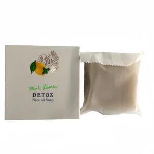 The cooling Mint and Hotel Soaps Lemon DETOX Natural Soap placed on a bamboo shower tray inside a high-end hotel wellness spa.