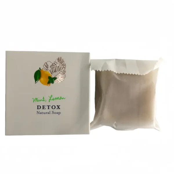 The cooling Mint and Hotel Soaps Lemon DETOX Natural Soap placed on a bamboo shower tray inside a high-end hotel wellness spa.