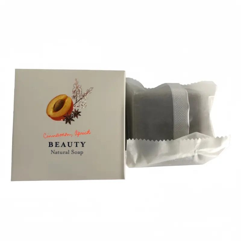 The Cinnamon and Apricot Hotel Organic Natural Soap placed elegantly on a bamboo tray next to a steaming freestanding resort bathtub.