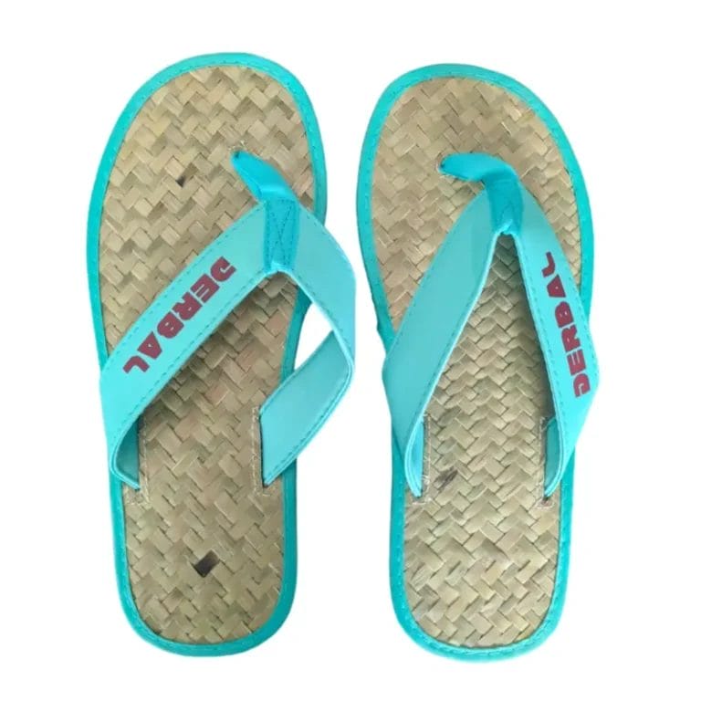 A macro close-up of the textured, high-friction rubber outsole on the bottom of the Raffia Straw Flip Flops.