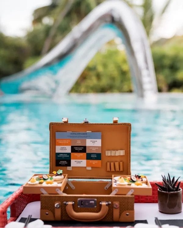 Custom laser-engraved hotel logo on a leather tag attached to a wicker picnic basket.