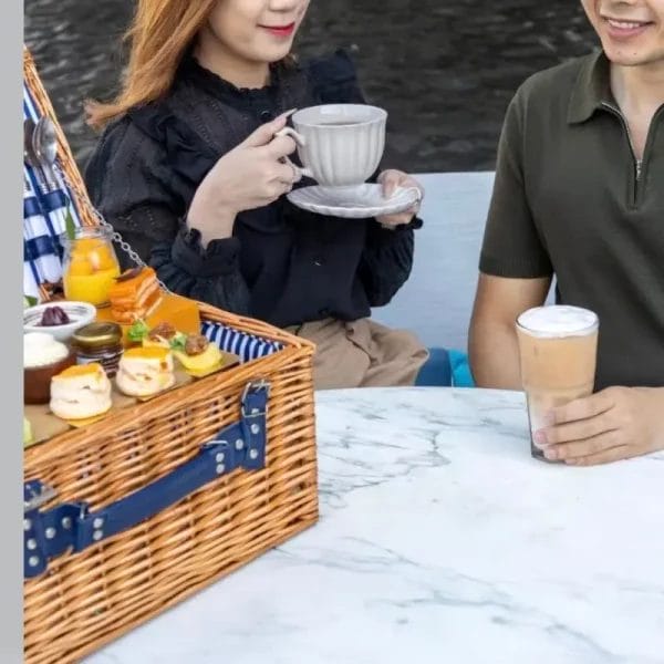 A rustic wicker picnic basket placed on sand dunes for a luxury desert safari dining experience in Dubai.