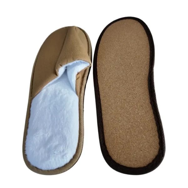 A pair of Hotel Indoor Slippers set by the bedside for a professional turndown service.