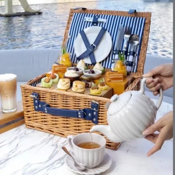 Internal view of a wicker picnic basket showing removable linen lining and bottle security straps.