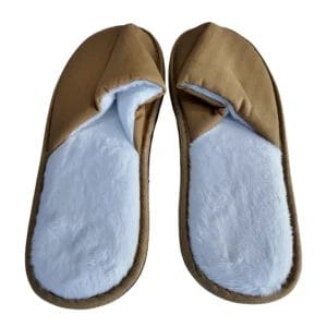 Hotel Indoor Slippers placed elegantly on a polished wood floor in a luxury hotel suite.