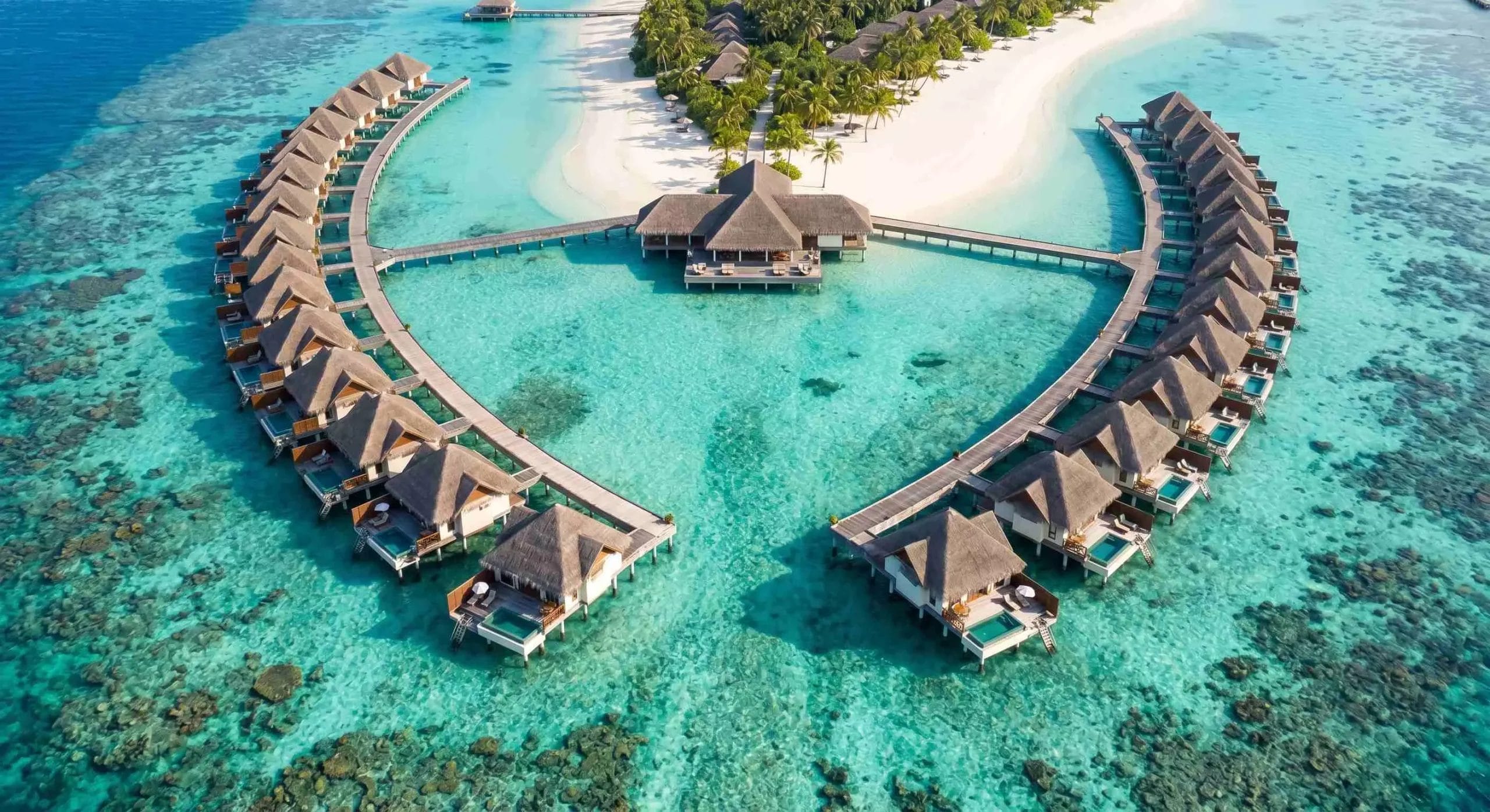 Maldives luxury resort hotel supplies aerial view overwater villas turquoise lagoon 2026