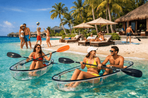 Happy guests enjoying water sports and transparent kayaks at a luxury beach resort.