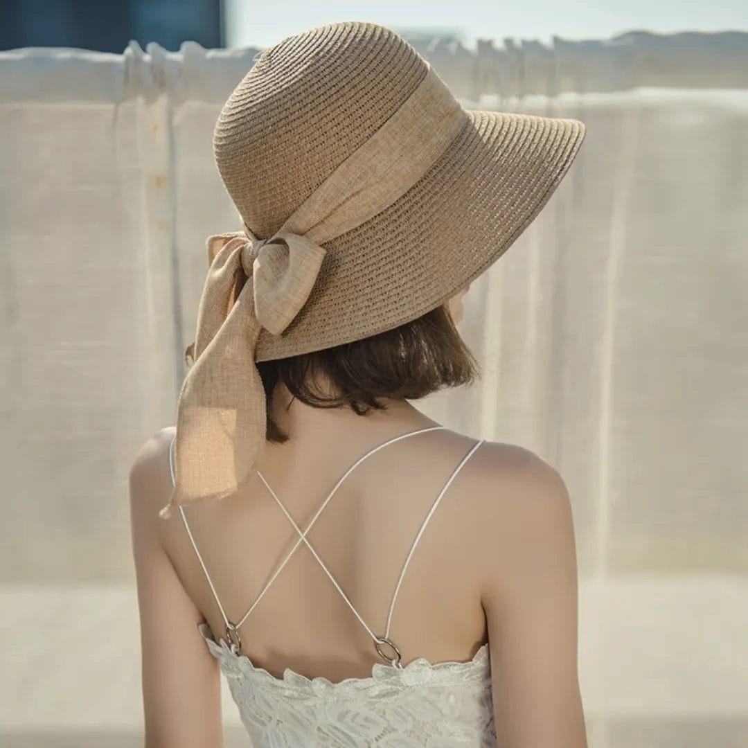 A guest wearing a wide-brim Beach Sun Straw Hat at a luxury Maldives resort pool.